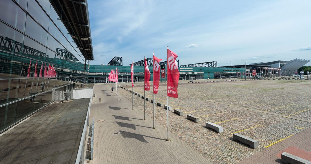 Außenaufnahme Überblick gesamtes Gelände mit Fahnen mit MESSE BREMEN-Logo vor Halle 7
